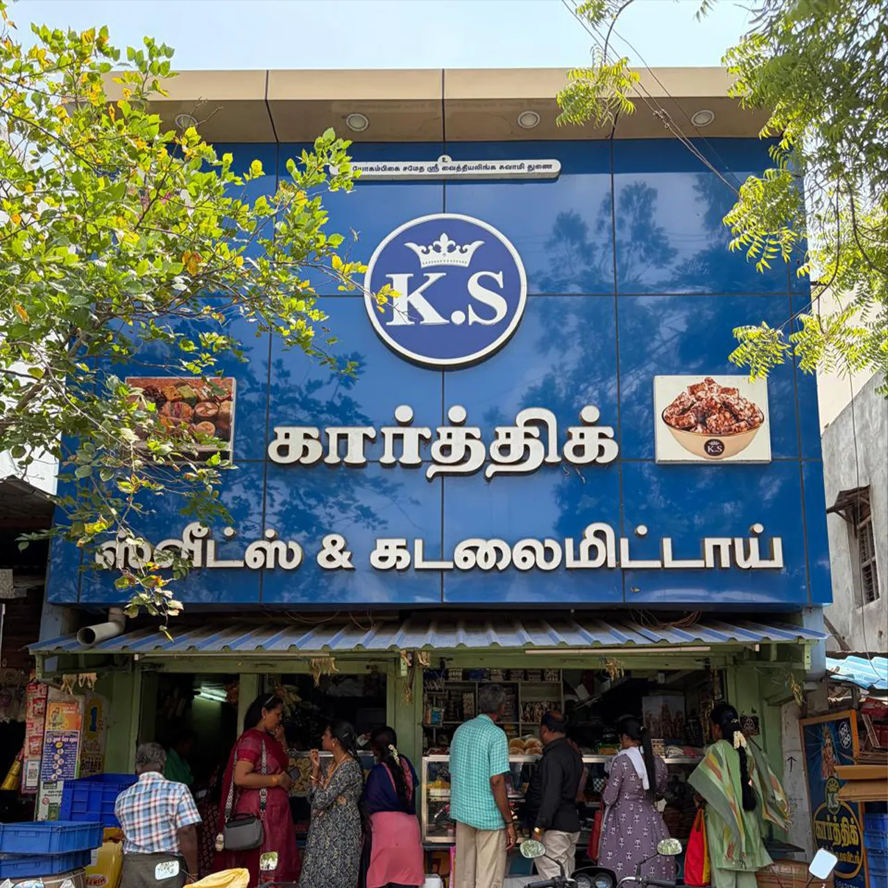 The Karthick Sweets shopfront in Kovilpatti, customers at the counter